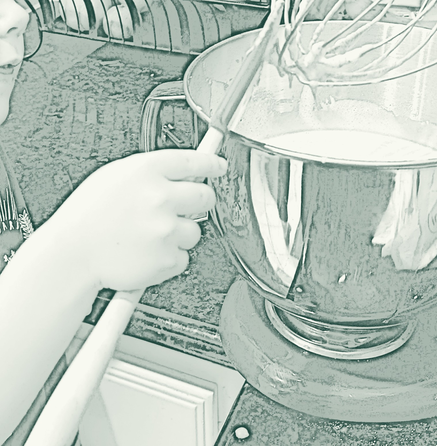 A child's hands holding a wire whisk over a mixing bowl on the counter